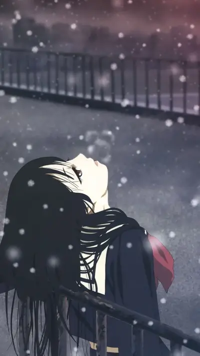 A girl in a school uniform looks up at falling snow