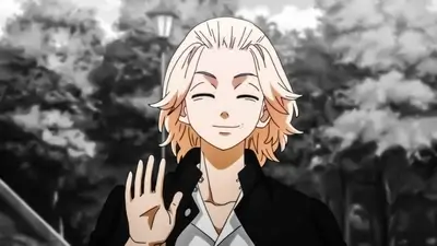 Blonde haired boy smiling and waving his hand outdoors