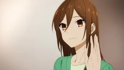Brown-haired girl in green top waving her hand