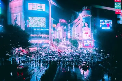 Busy Shibuya crossing on a rainy night in Japan