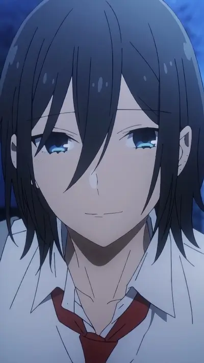 Close-up of a smiling boy with dark hair and blue eyes