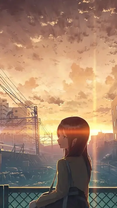 Girl sitting by a fence, watching sunset over cityscape
