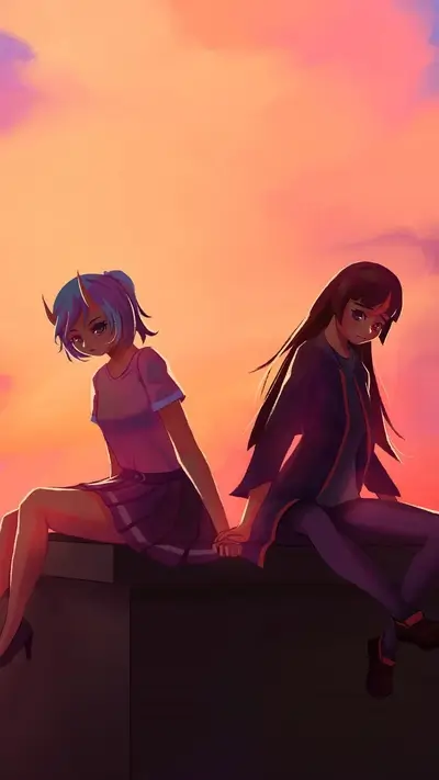 Girls sitting closely together at sunset, holding hands