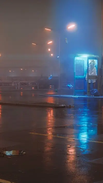 Lonely figure in a rain-swept phone booth