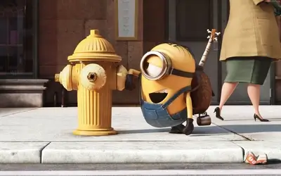 Minion standing next to fire hydrant, woman walking in background