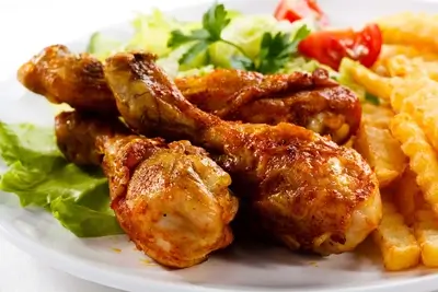 Roasted chicken drumsticks with fries and salad