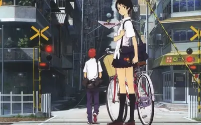 Schoolgirl standing with bicycle at urban railway crossing
