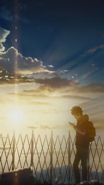 Silhouette of a person looking at a phone during sunset