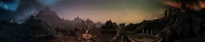 Sweeping panorama capturing a medieval village under a sky painted with auroral hues.