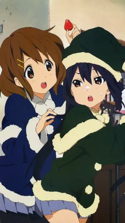 Two girls in winter clothes, one holding a strawberry