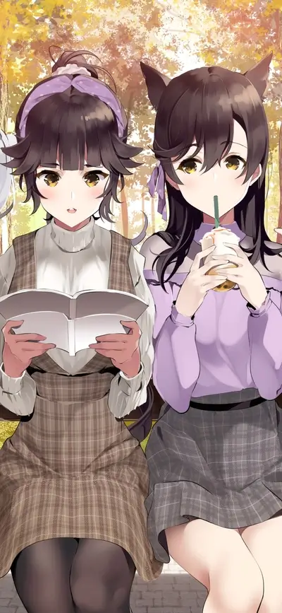 Two girls sitting on a bench in autumn