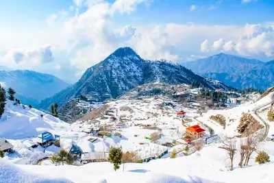 Winter wonderland: snow-covered village nestled amidst majestic mountains under a bright sky