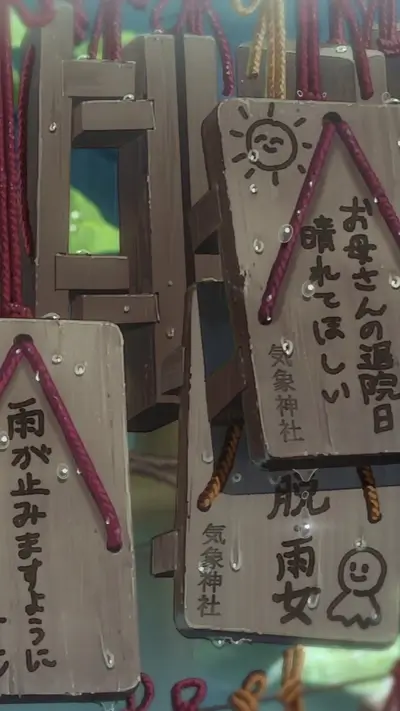 Wooden Ema plaques hanging outdoors in the rain